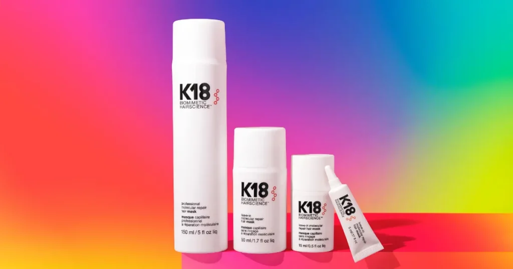 K18 haircare products on vibrant gradient background.