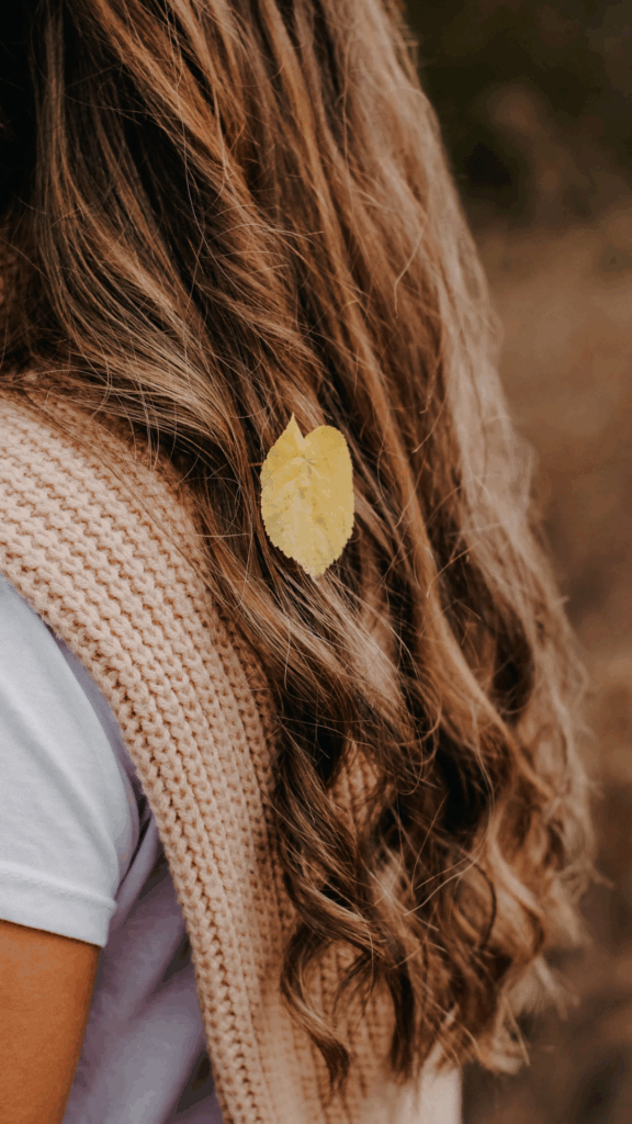 Yellow leaf in curly hair, autumn style
